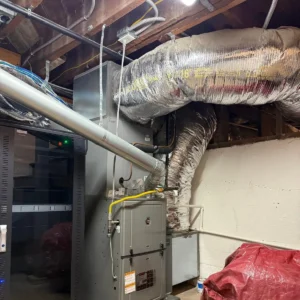 Furnace with insulated flexible duct routed through attic framing
